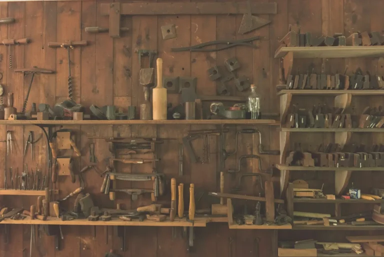 An old workshop wall lined with hand tools on wooden shelves