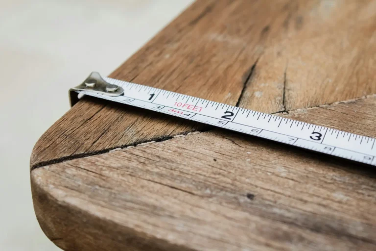 A tape measure laid across a weathered wooden table